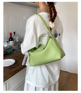 Detail of avocado green leather shoulder bag with lychee texture and natural folds