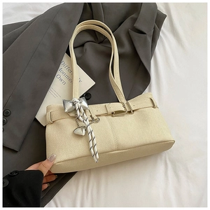 Detail of off-white bucket bag with silver buckle and braided bow heart pendant