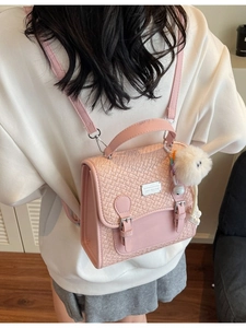 Petit sac à dos rose tissé pour femme avec pompon blanc et plaque métallique argentée