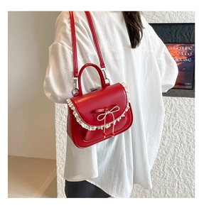Dettaglio della borsa rossa in ecopelle con bordi in pizzo bianco e decorazione a fiocco