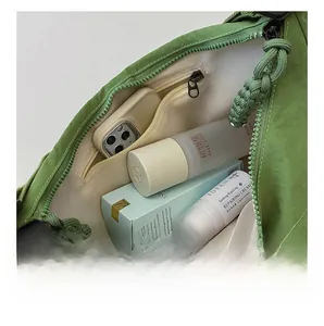 Vista dall'alto della spaziosa borsa a tracolla in nylon verde con tasca interna con zip