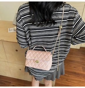 Close-up of pink quilted leather shoulder bag featuring gold twist lock and chain strap
