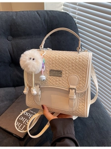 Sac à dos chic beige tissé avec breloque peluche monstre et sangle réglable