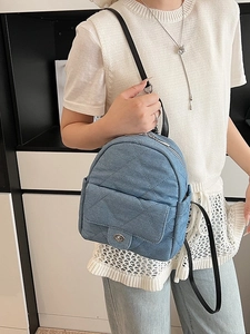 Light blue quilted denim mini backpack with silver twist lock shown on model