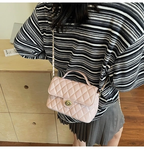 Detailed back view of pink quilted chain bag worn by a model in a cozy home setting