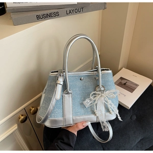 Detail der hellblauen Denim-Beuteltasche mit Silberbesatz und Spitzen-Perlen-Anhänger