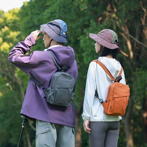Outdoor backpacks in grey and orange with UPF 50+ sun hat in a forest setting