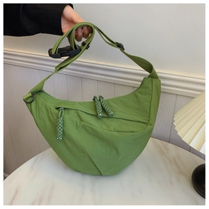 Dettaglio borsa a mezzaluna verde con trama in nylon plissettato e tirante in corda intrecciata