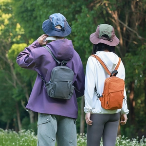 Outdoor backpacks in grey and orange with UPF 50+ sun protection clothing in nature