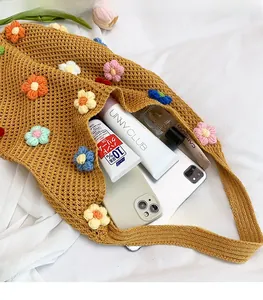 Interior view of yellow crochet tote showing spacious storage with makeup and phones