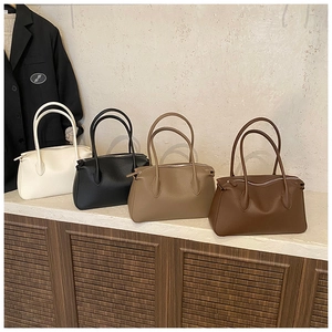 Litchi pattern tote bags in beige black khaki and dark brown on a wooden display