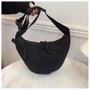 Dettaglio borsa a tracolla a mezzaluna in nylon nero con tracolla larga e lacci intrecciati