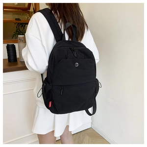 Close-up of functional black nylon backpack with multiple zipper pockets and wide straps