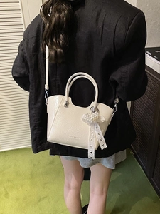 Fashionable cream bucket bag with pleated texture and pearl heart charm on model