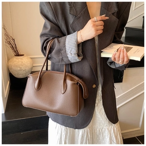 Brown lychee leather tote bag with sturdy top handles and premium metal zipper detail