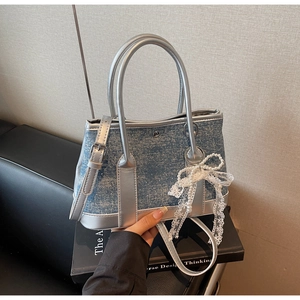 Detail der blauen Denim Beuteltasche mit silbernem Leder, Spitzenschleifen und Perlen