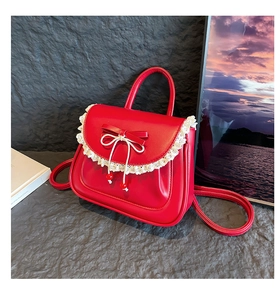 Dettaglio della borsa in pelle opaca rossa con bordo in pizzo bianco e decorazione