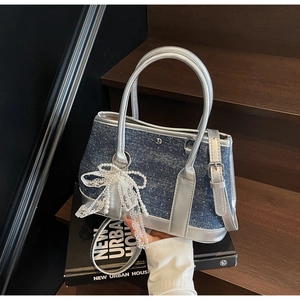Details der silbernen Eimertasche aus Leder und Denim mit Perlenbogen und Glitzerdekor