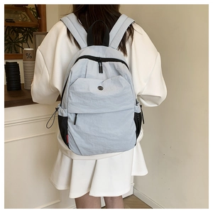 Detail of waterproof nylon backpack with dual zippers and mesh side pockets