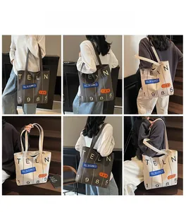 Detailed views of high-capacity canvas tote bags in grey and off-white with shoulder straps