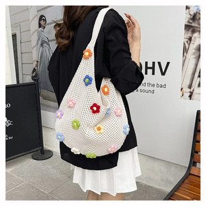 Détail du sac cabas en maille tissé main avec fleurs 3D colorées sur tissu crème