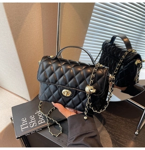 Detailed close-up of quilted square bag with gold hardware and skull charm detail