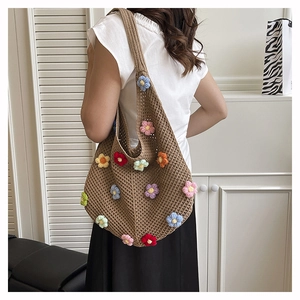 Détail d'un sac cabas en crochet fait main avec fleurs 3D colorées et texture en tricot