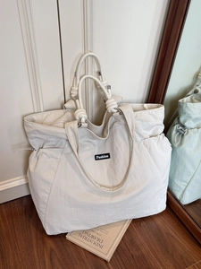 Large capacity nylon tote bag in cream white with knot handles and fashion label