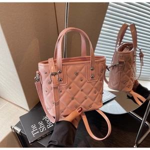 Detailansicht der rosa gesteppten Beuteltasche mit Nieten und verstellbarem Riemen in Lifestyle-Szene