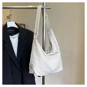 Detail of off-white nylon hobo bag showing pleated texture and floral metal logo