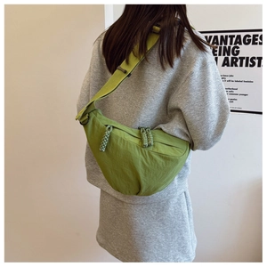 Dettaglio della borsa a tracolla a mezzaluna verde frutta con tiranti della zip intrecciati
