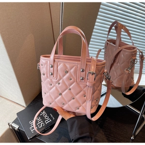 Detail der rosa Lackleder-Eimertasche mit silbernen Nieten und gestepptem Rautenmuster