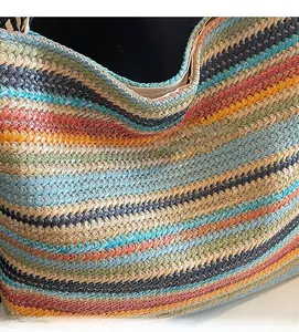 Close-up of colorful striped woven texture on large straw shoulder bag for summer