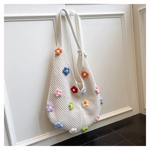 Detailed view of handmade white crochet tote bag with colorful 3D knitted floral patterns