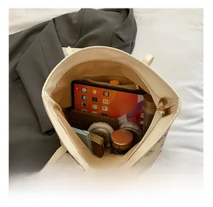 Interior view of white tote bag showing large capacity for tablet and cosmetics