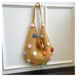 Detailed knit texture of a yellow crochet tote bag with colorful 3D floral accents