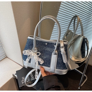 Detail der Handtasche aus blauem Denim und Silbermetallic mit Perlen und Spitzenschleife