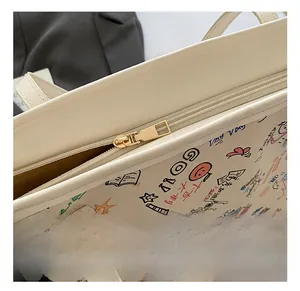 Detail of colorful graffiti tote bag with smooth gold hardware and grain leather