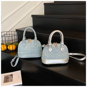 Detail of shell-shaped crossbody bags with sparkling rhinestones and leather handles