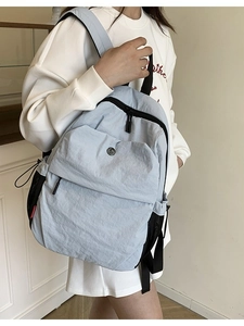 Minimalist light blue casual backpack for women featuring a side mesh water bottle pocket
