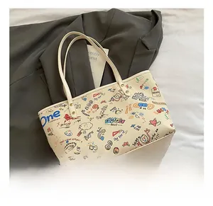 Flat lay of off-white tote bag with colorful graffiti art and elegant slim handles