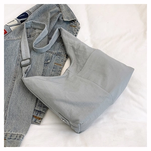 Detailed top view of light blue nylon tote bag with adjustable shoulder strap and texture