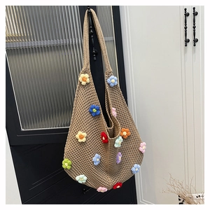 Detail of handmade crochet hobo bag with colorful 3D knitted flower patterns