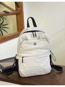 Minimalist off-white nylon backpack for women featuring stylish black contrast straps