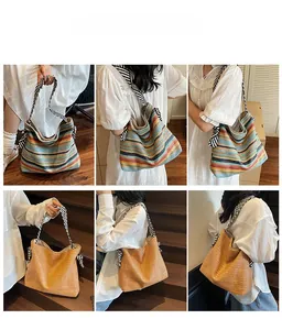 Detail of bohemian woven straw tote bag with striped straps and large capacity for beach