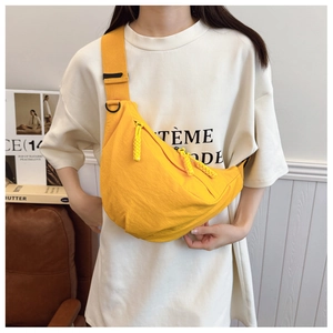 Dettaglio borsa a tracolla a mezzaluna in nylon giallo brillante con ampia tracolla su modella