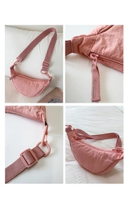 Pink nylon crescent bag with adjustable wide strap and detailed zipper close-up view