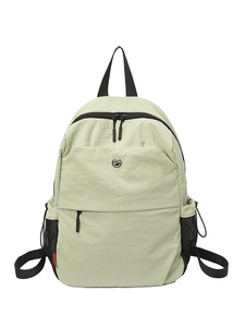 Light green nylon backpack for women featuring double zippers and mesh side pockets