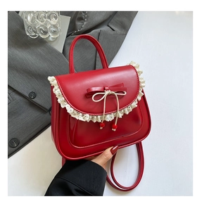 Dettaglio della borsa rossa con bordo in pizzo beige e fiocco in pelle decorativo