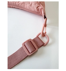 Detailed close-up of pink nylon dumpling bag showing strap, plastic buckle and fine stitching